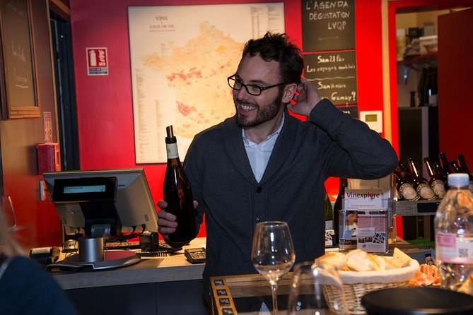 Atelier dégustation vins et fromages Paris quartier latin with a photo of a tourist holding the bottle of wine.