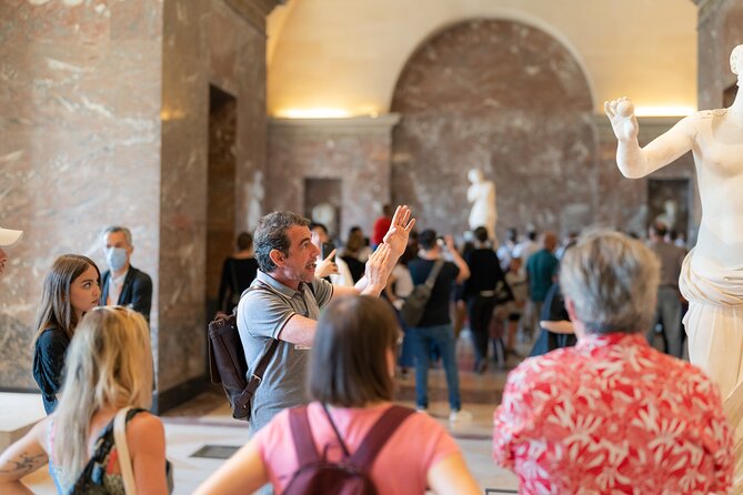 Louvre Museum Skip the Line Must-Sees Guided Tour featuring tourists appreciating the work of art in the musuem.