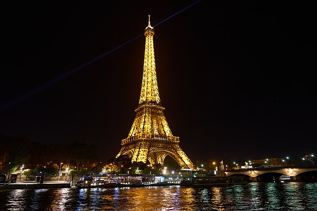 Eiffel Tower at night, illuminated by yellow lights