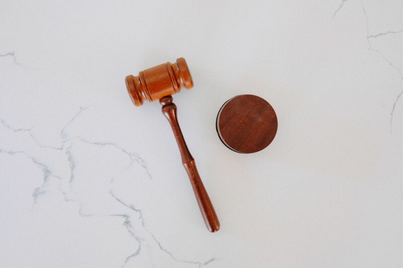 A judge's gavel on a white marble surface