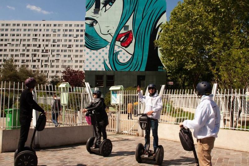 Group of people with an electric skate strolling with Paris Murals