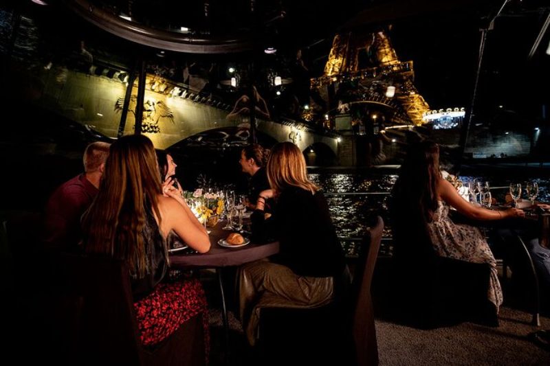 People at a Cruise Dinner Overlooking the Eiffel Tower At Night
