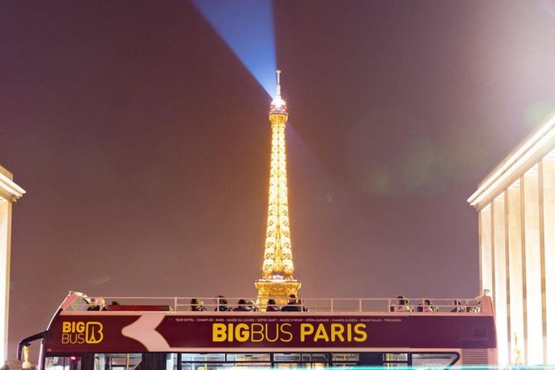 Big Bus at night with an illuminating Eiffel Tower in the background