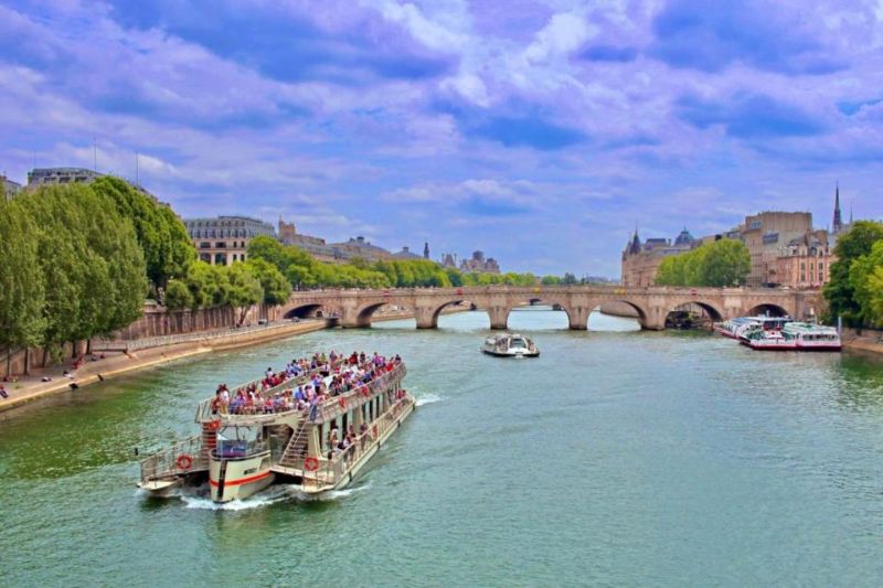 Drone shot of a boat on a day tour overlooking the whole city of Paris