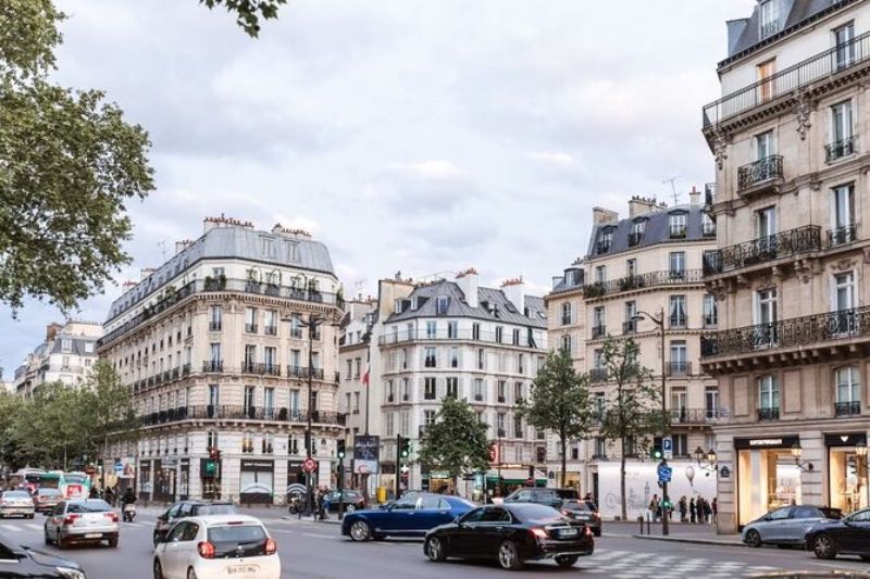 a neighborhood with old buildings and cars