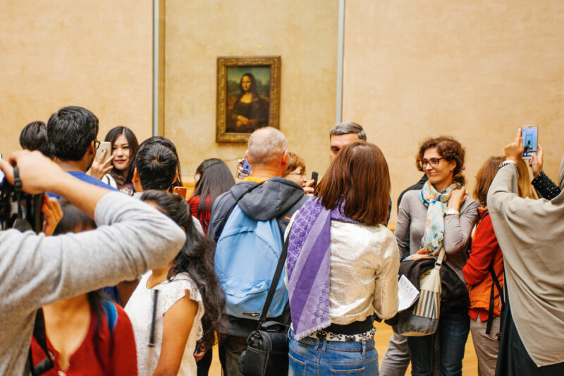 Visitors take photo of Leonardo DaVinci's "Mona Lisa" at the Louvre Museum