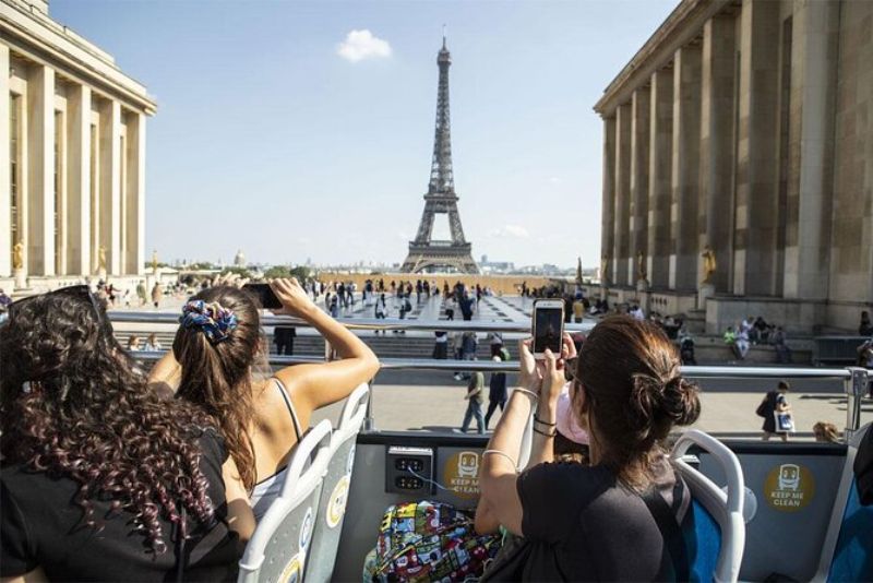 People In An Open Bus Taking Photos Of The Eiffel Tower