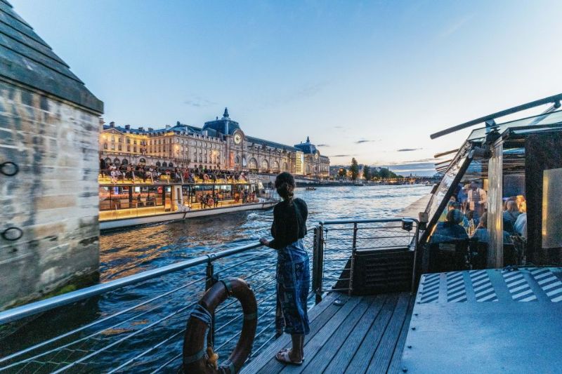 a girl tourist enjoying the cruise view at night in Paris