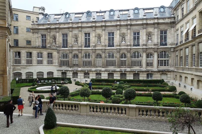 a group of tourist exploring the building and gardens in Paris France