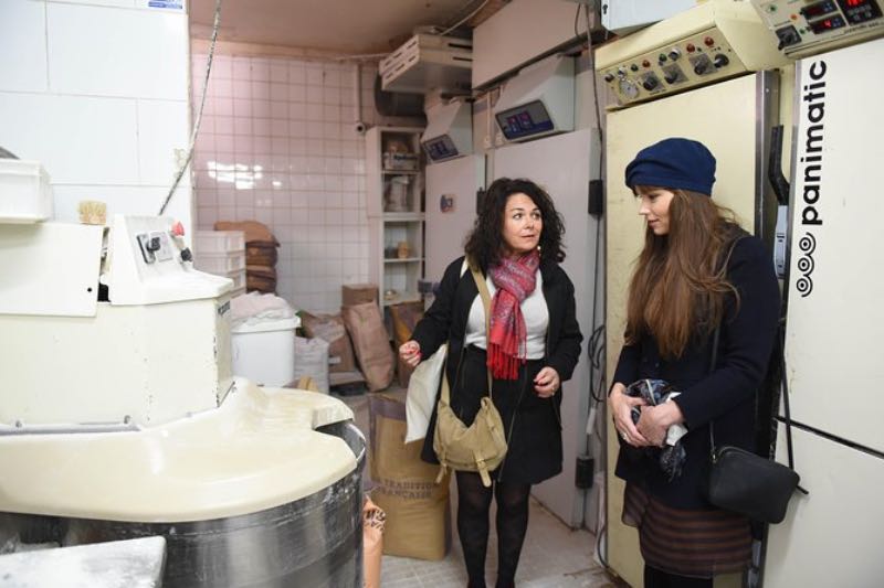 a tourist and a tour guide in a food tour exploring the kitchen area