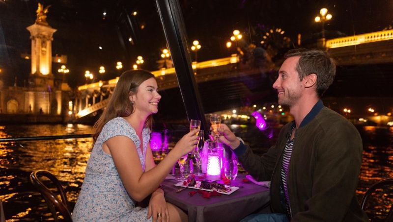 Couple having wine in a paris cruise