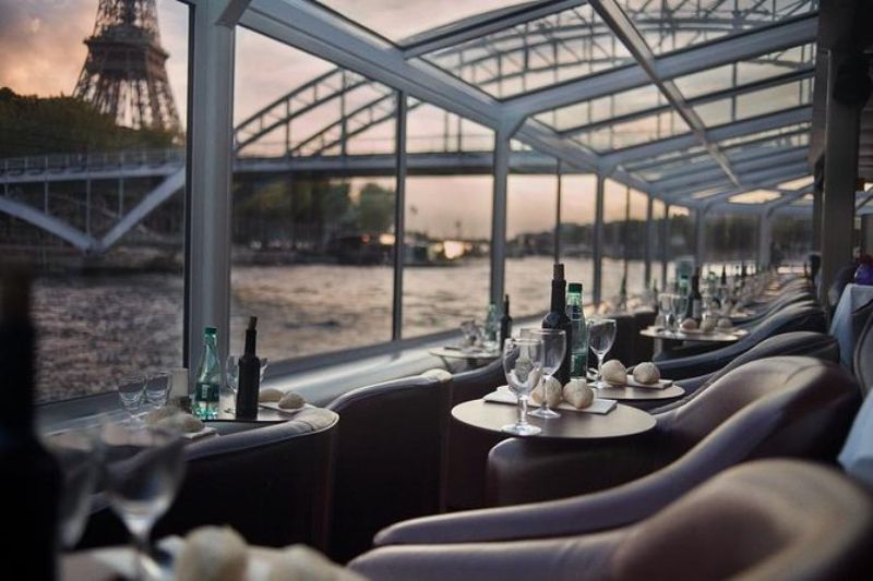 Dining set up in a glass-coated boat cruise overlooking the Eiffel Tower