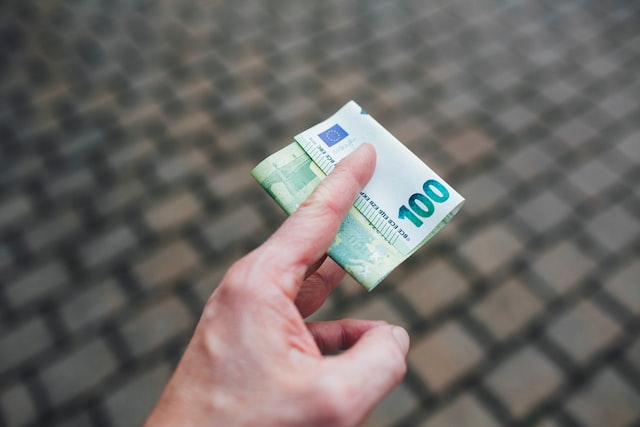 a person holding euro bill