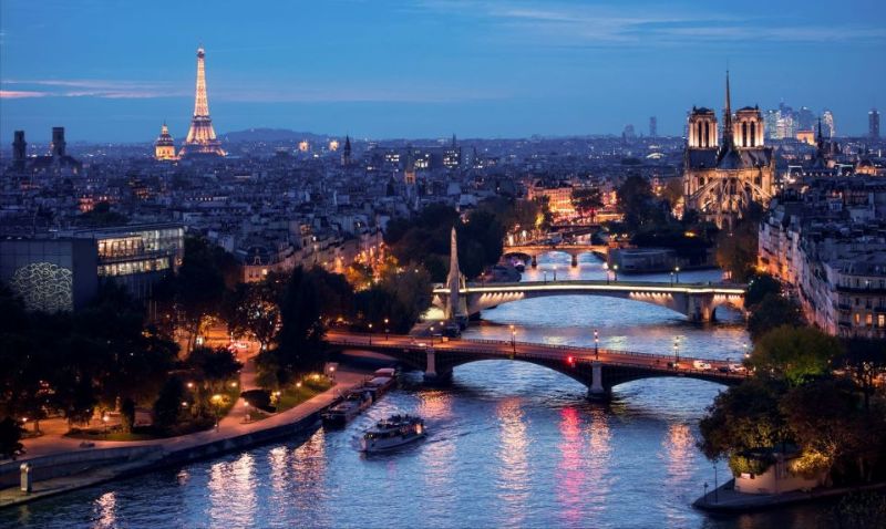 panoramic night view of a boat in the river overlooking the city of Paris