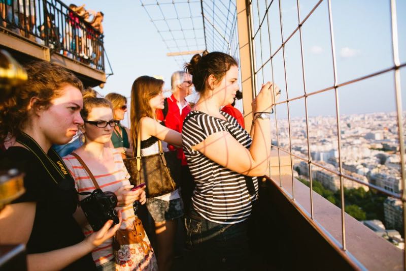 tourists enjoying the sunset at the top of the Eiffel Tower