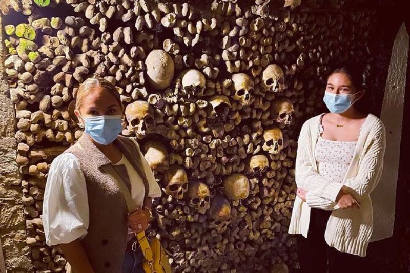 Two female tourists in the Paris Catacombs