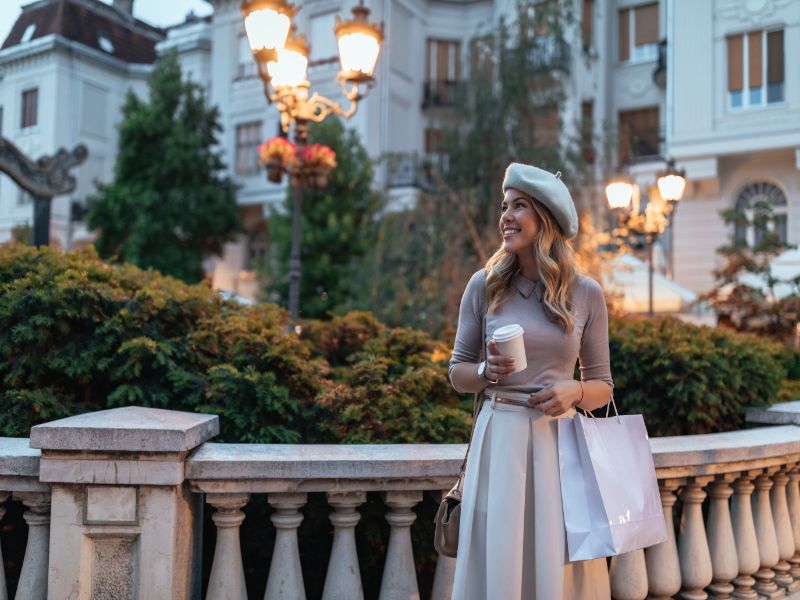 Happy young woman with cup of coffee in Paris