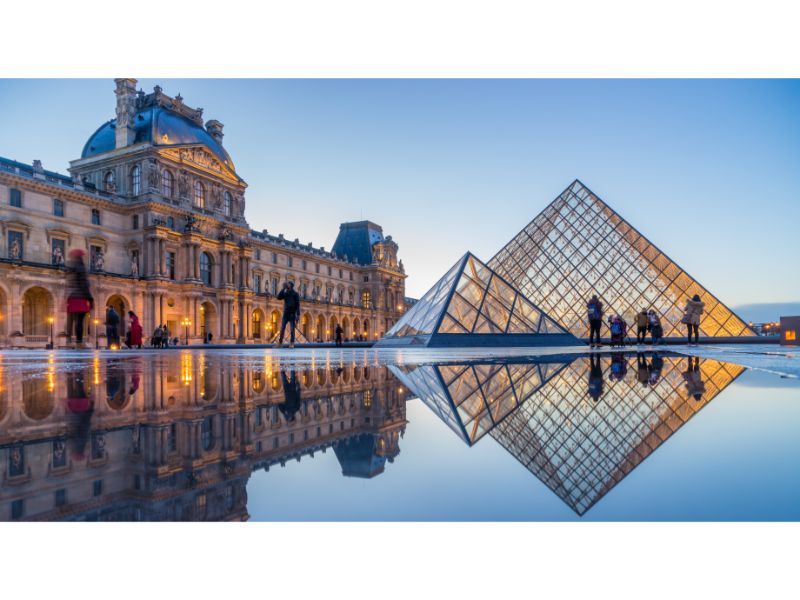 View of famous Louvre Museum with Louvre Pyramid at evening