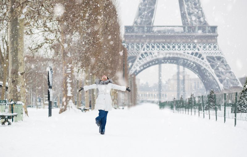 Woman dancing in the snow near the Eiffel Tower