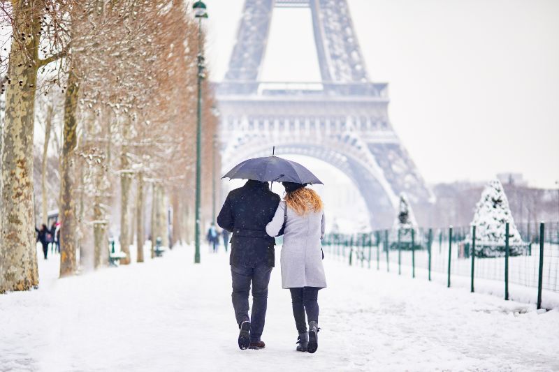 Couple of tourists walking in Paris on a day with heavy snow