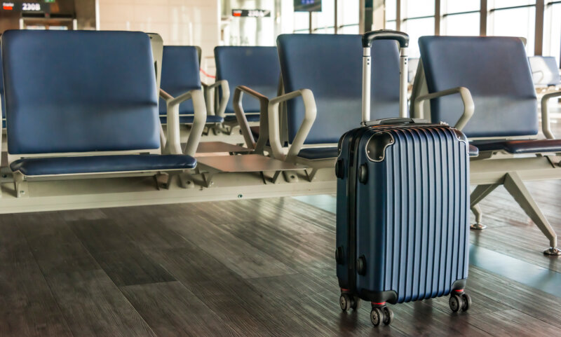 Plastic travel suitcase in the airport hall