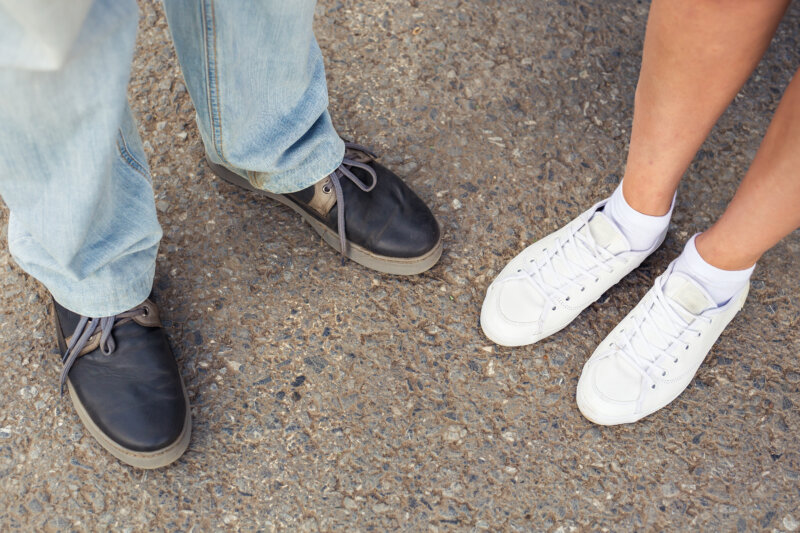 Closeup of male and female shoes during a date