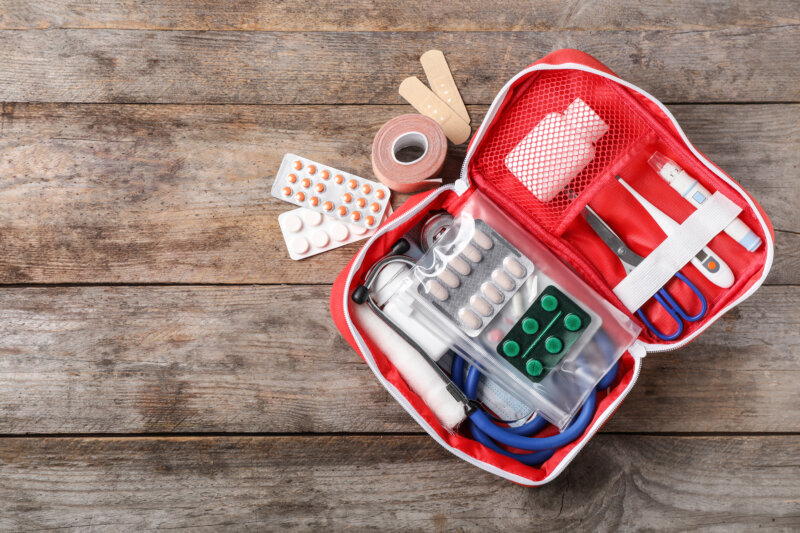 Flat lay composition with first aid kit and space for text on wooden background