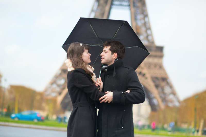 Couple with umbrella near the Eiffel tower