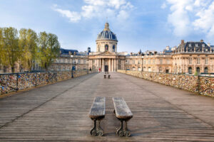 Pariss Pont des Arts with lovelocks, bench, and Institut de France backdrop.