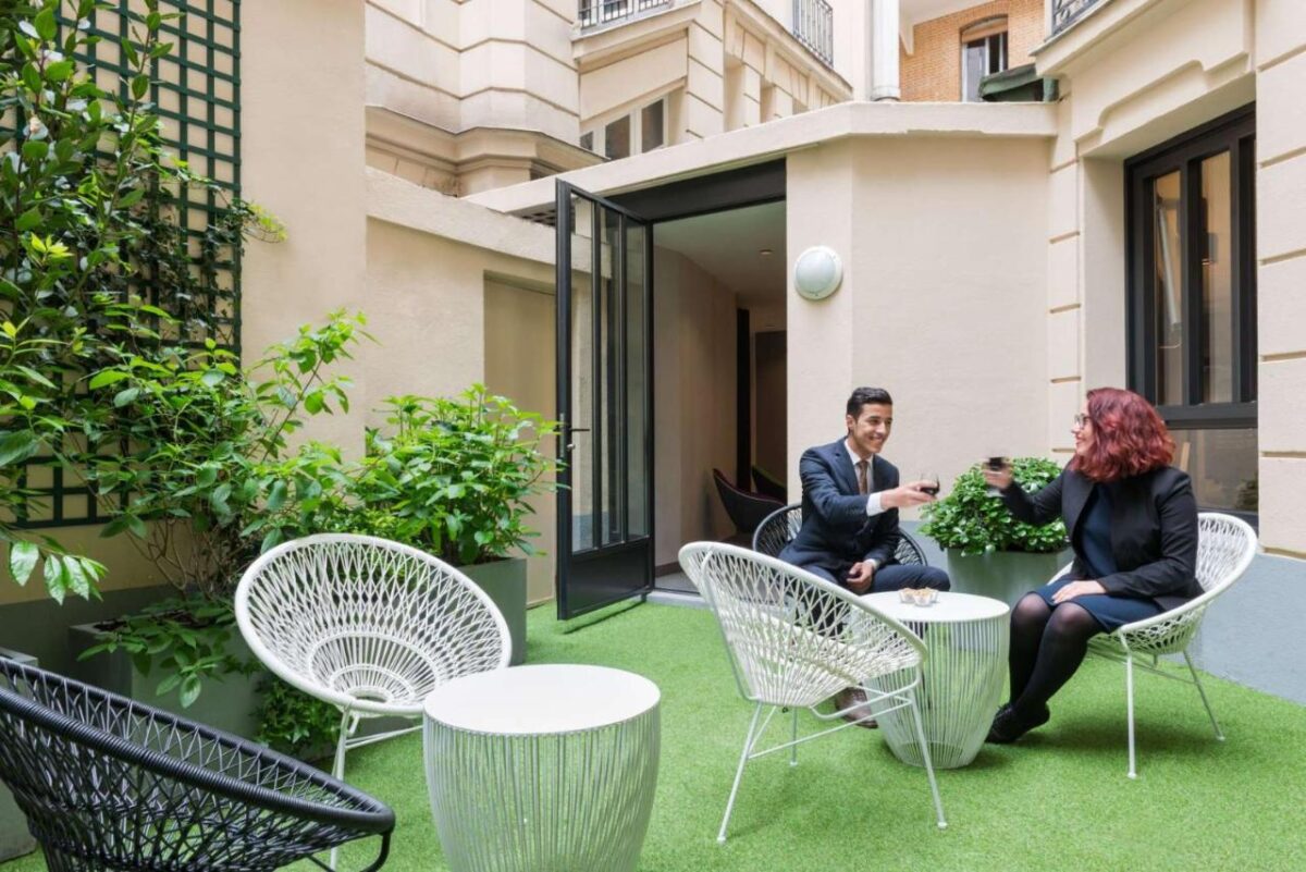 Hôtel Paris Vaugirard with an outdoor set of chairs and tables