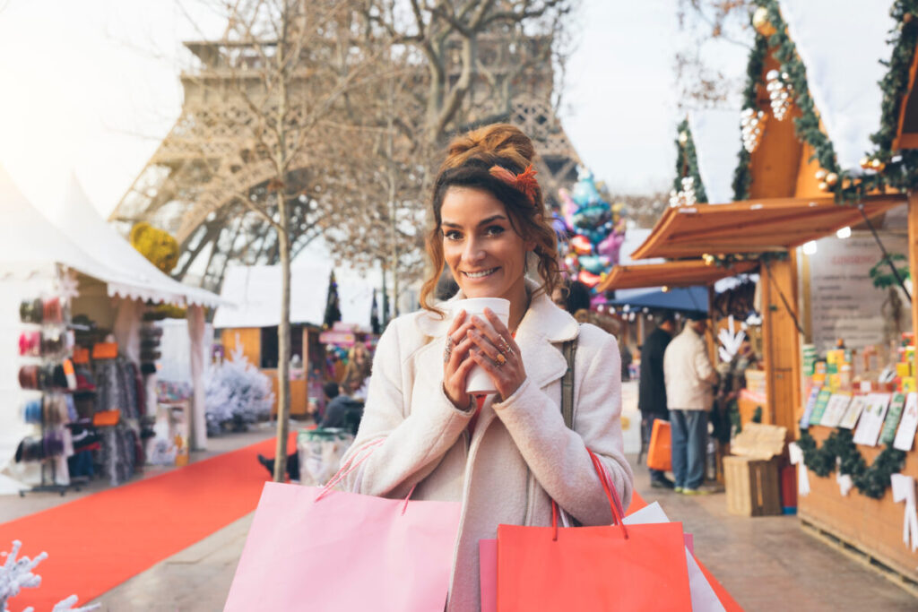 Woman visiting a Parisian christmas market with Eiffel tower in