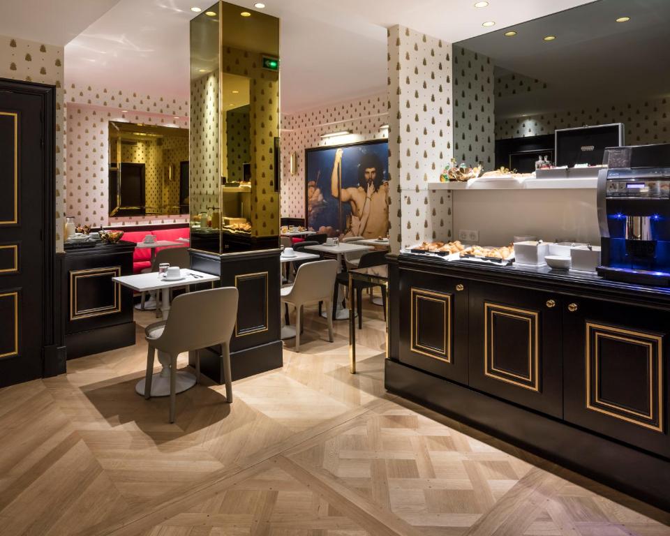 The lobby of Hotel Eiffel Petit Louvre enchants with a blend of opulence and warmth, featuring plush furnishings and subtle golden accents that evoke a sense of sophistication.
