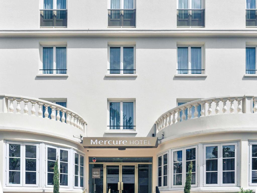 The exterior of Hôtel Mercure Paris Saint Cloud Hippodrome, a modern building with sleek architecture and expansive glass windows, exudes a contemporary elegance.
