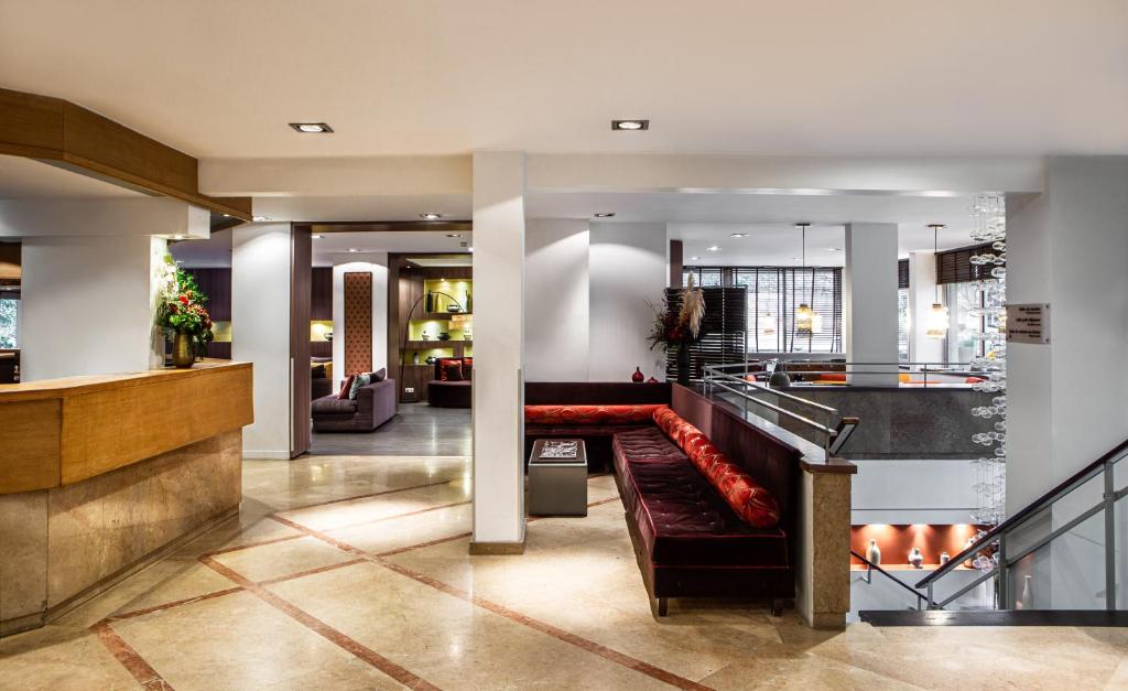 Hotel Paris Boulogne's lobby exudes elegance with its high ceilings, luxurious furnishings, and ambient lighting.
