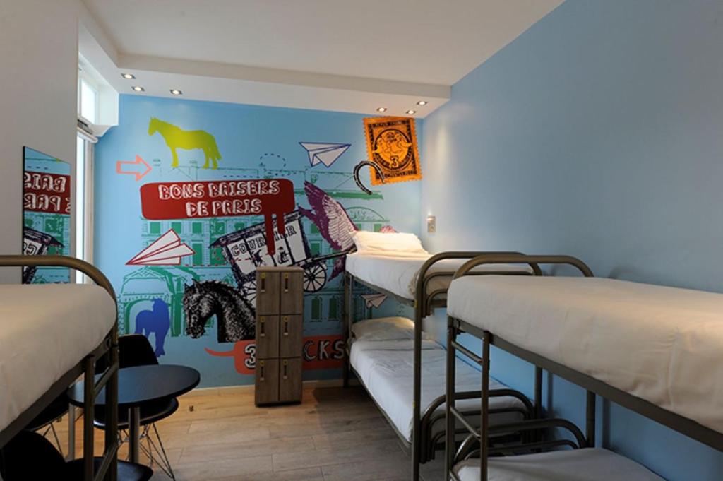 Bunk beds in a room adorned with a vibrant mural of the Eiffel Tower at The 3 Ducks Eiffel Tower by Hiphophostels