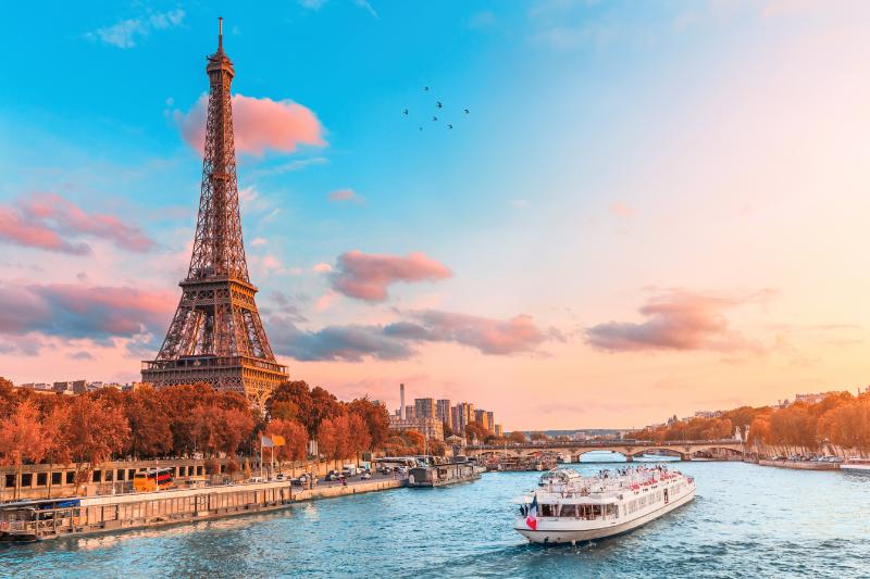 Eiffel tower in the rays of the setting sun on the bank of Seine river