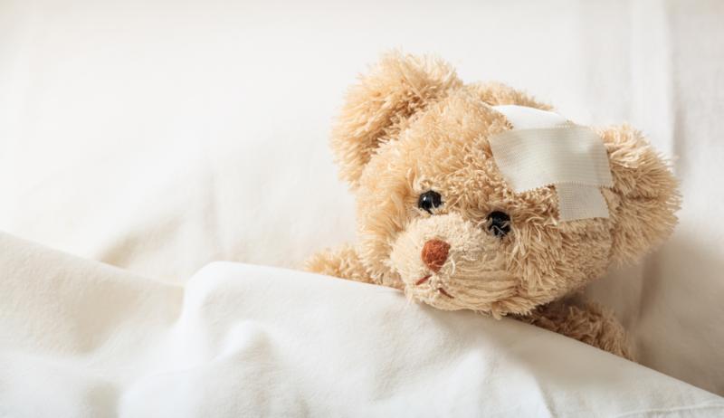 Teddy bear sick in bed