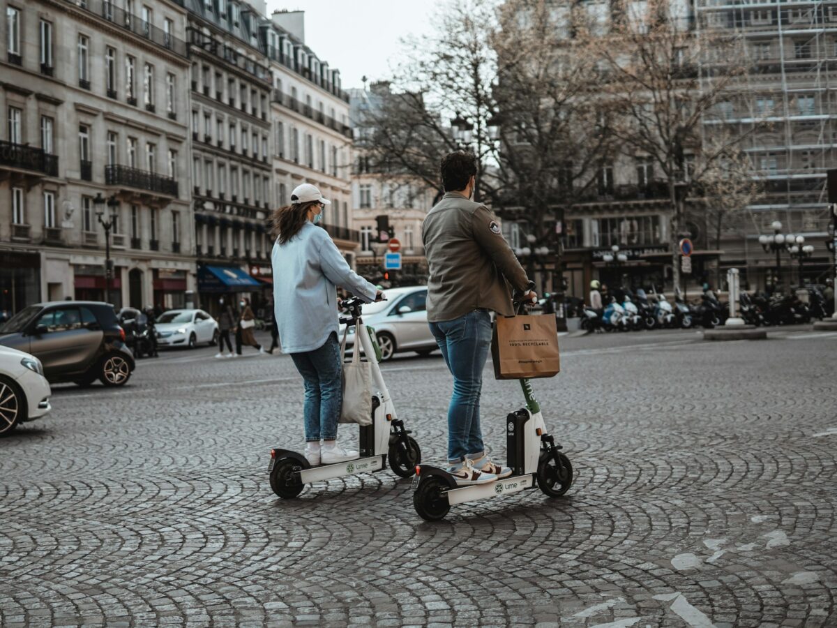 Two People Riding Electric Scooters in Paris
