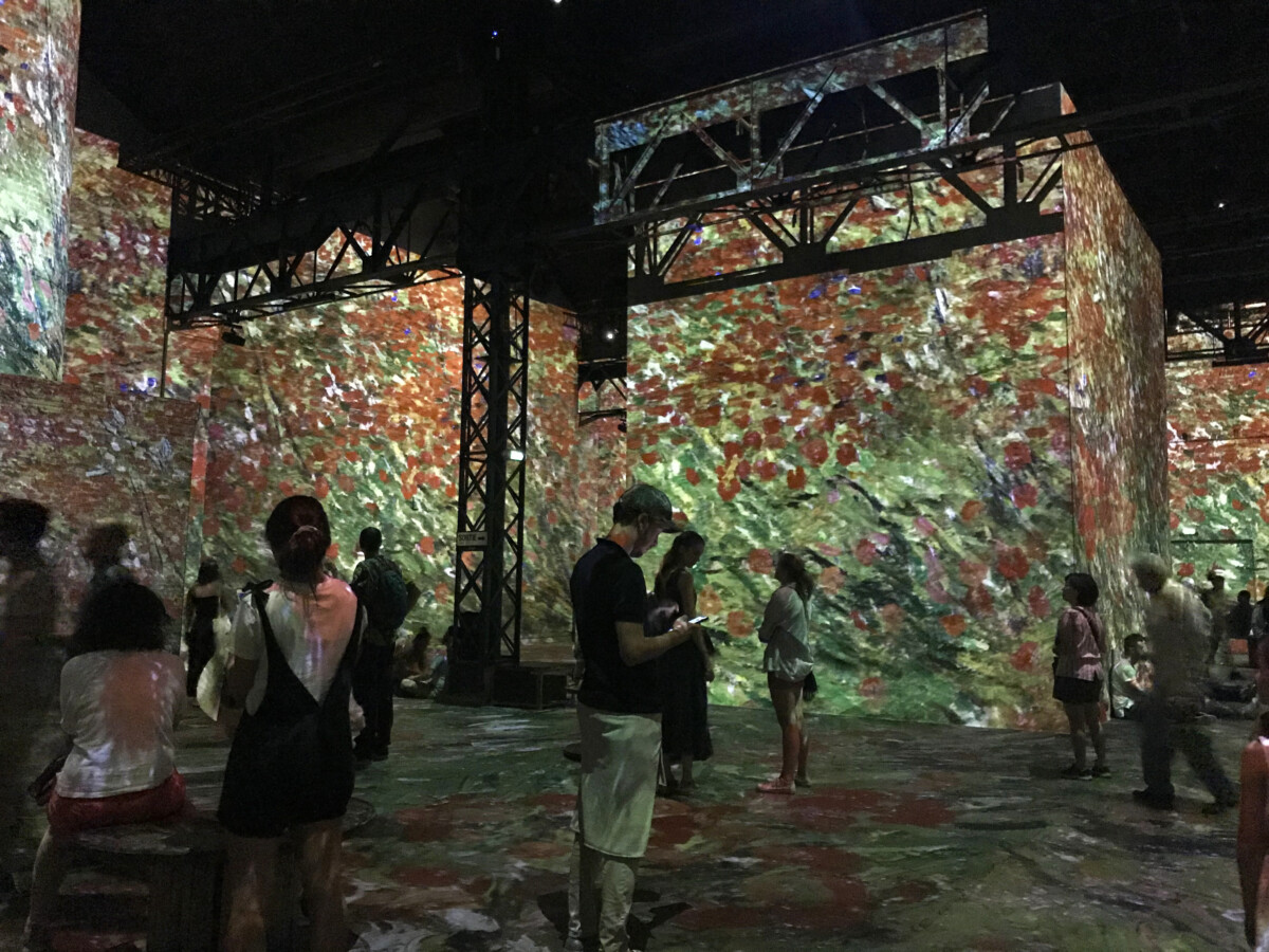 Van Gogh exhibitions at The Atelier des Lumières in Paris, showcasing tourists in immersive art experiences and vibrant projections