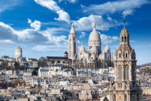 Panoramic view of the Basilica of Sacré-Cœur in Montmartre, Paris, showcasing its stunning architecture against the skyline.