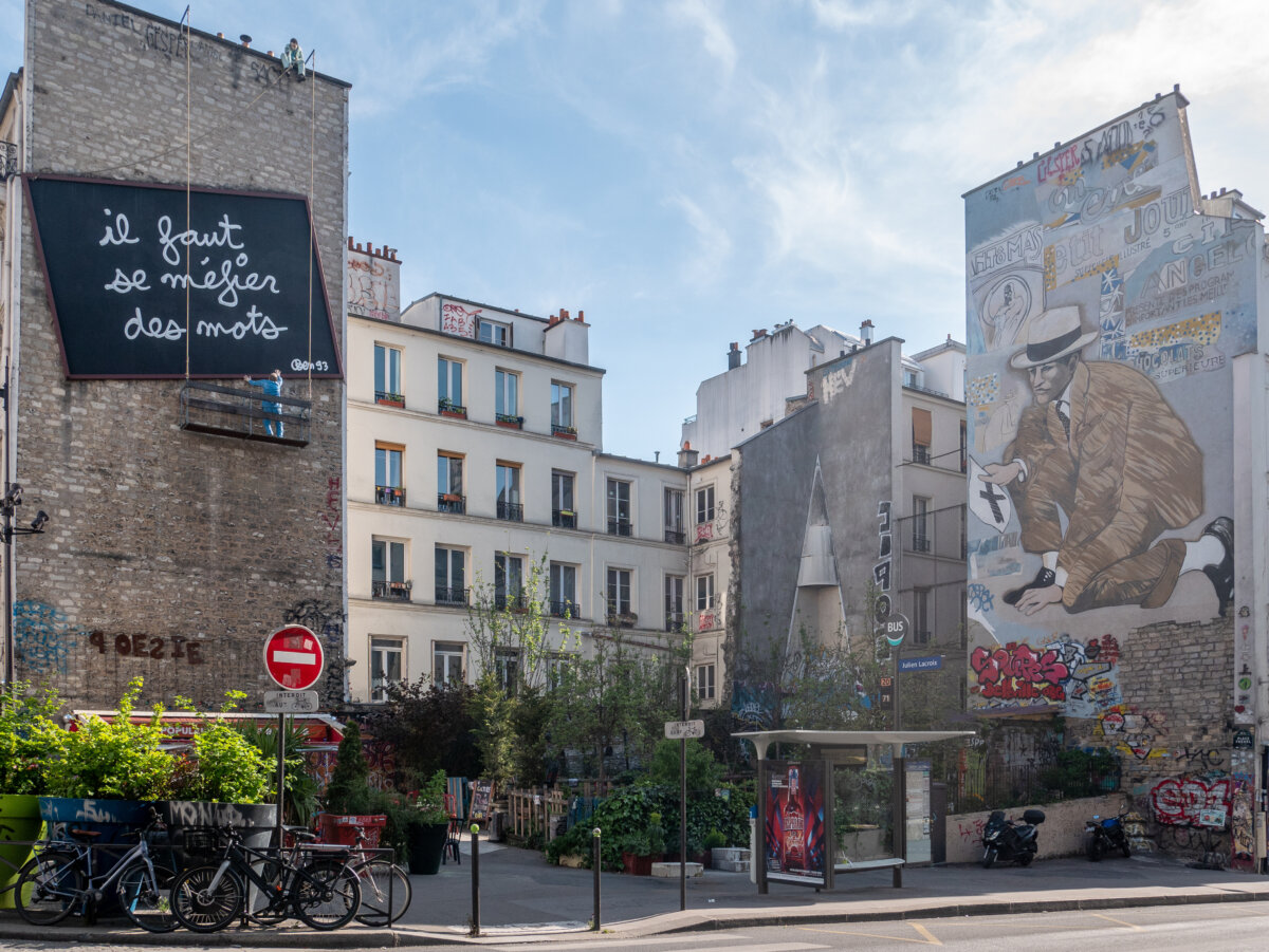Expansive street art murals decorate the facades of buildings on rue Belleville, reflecting the artistic spirit of Paris.