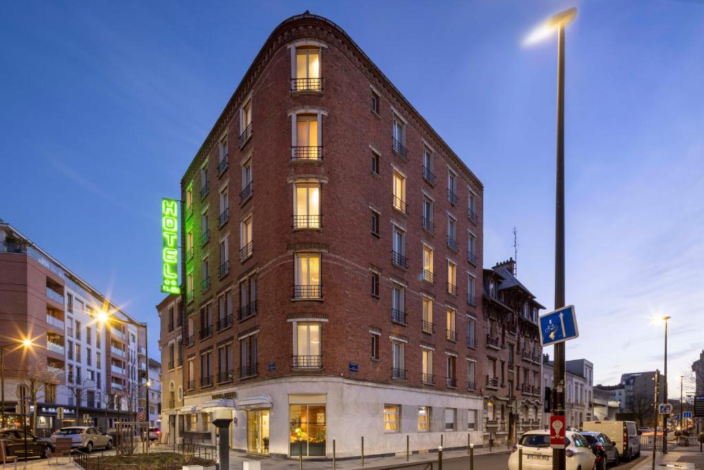 Exterior shot of Bijou Hôtel Paris Boulogne, showcasing its elegant architecture and welcoming facade, surrounded by lush greenery.