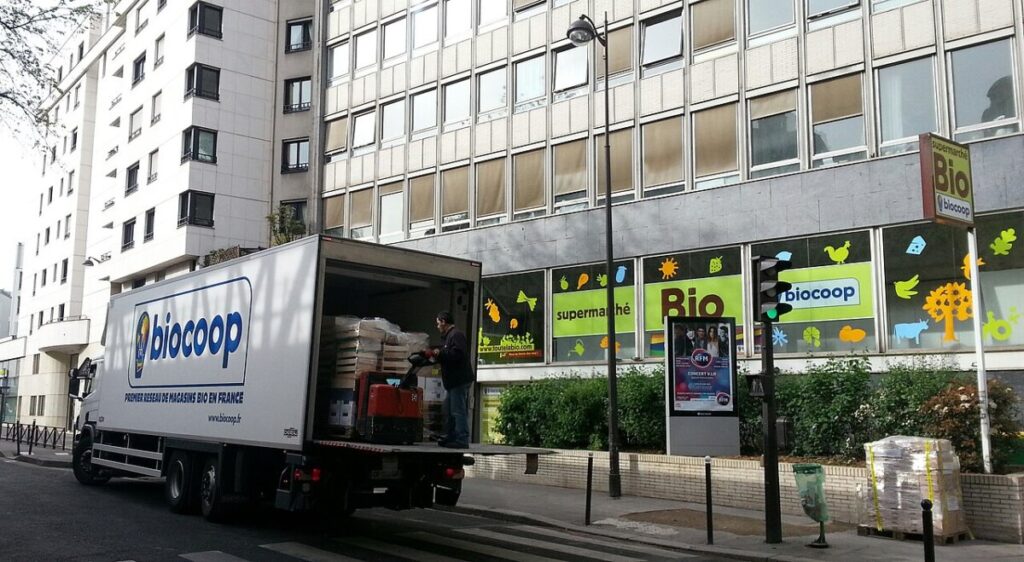 Truck parked in front of the Biocoop Paris building, showcasing the store's entrance and surrounding area.