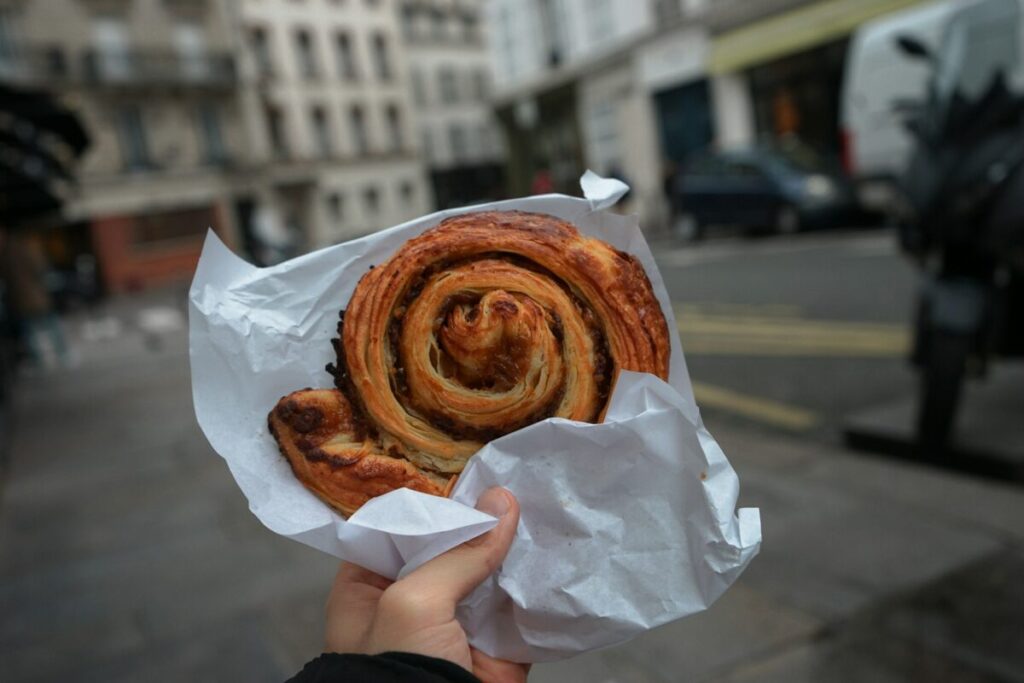 Hand holding a huge brown bread in Paris, France