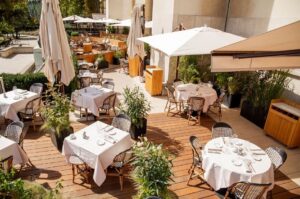 Café de l’Homme's patio in Paris, displaying neatly arranged tables and chairs for guests to enjoy their meals outside.