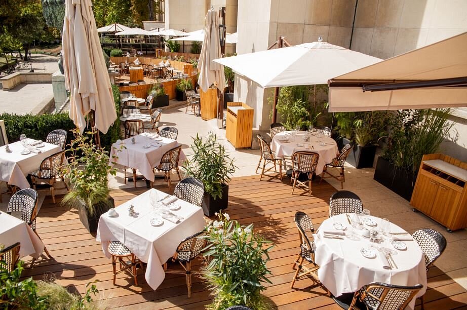 Café de l’Homme's patio in Paris, displaying neatly arranged tables and chairs for guests to enjoy their meals outside.