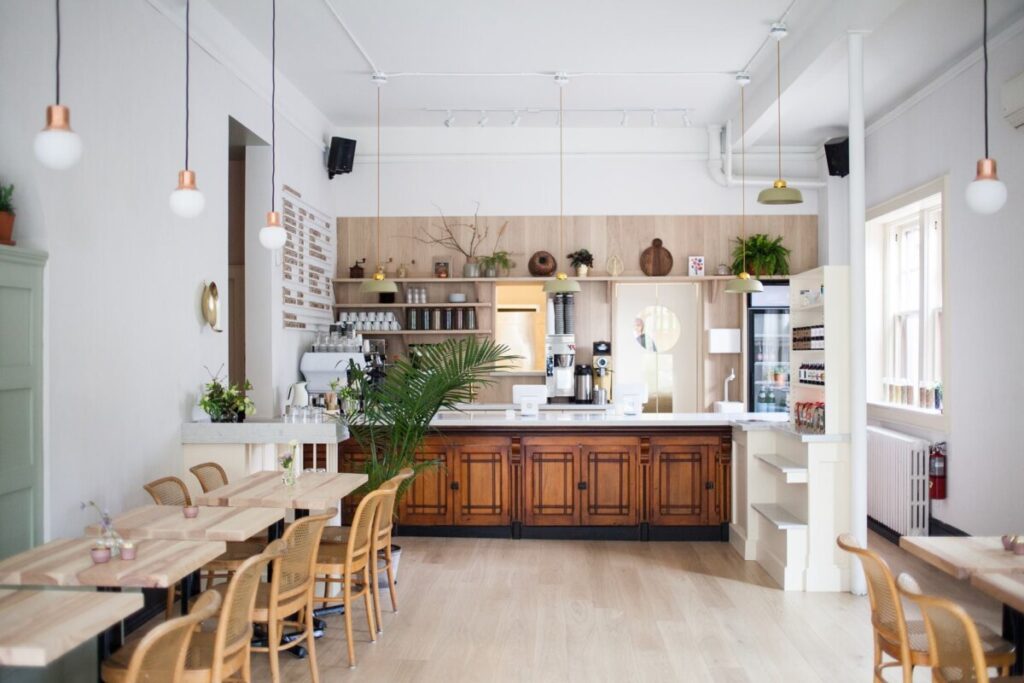 Inside Café Détour, Paris, showcasing rustic wooden tables and chairs in a warm, welcoming atmosphere.