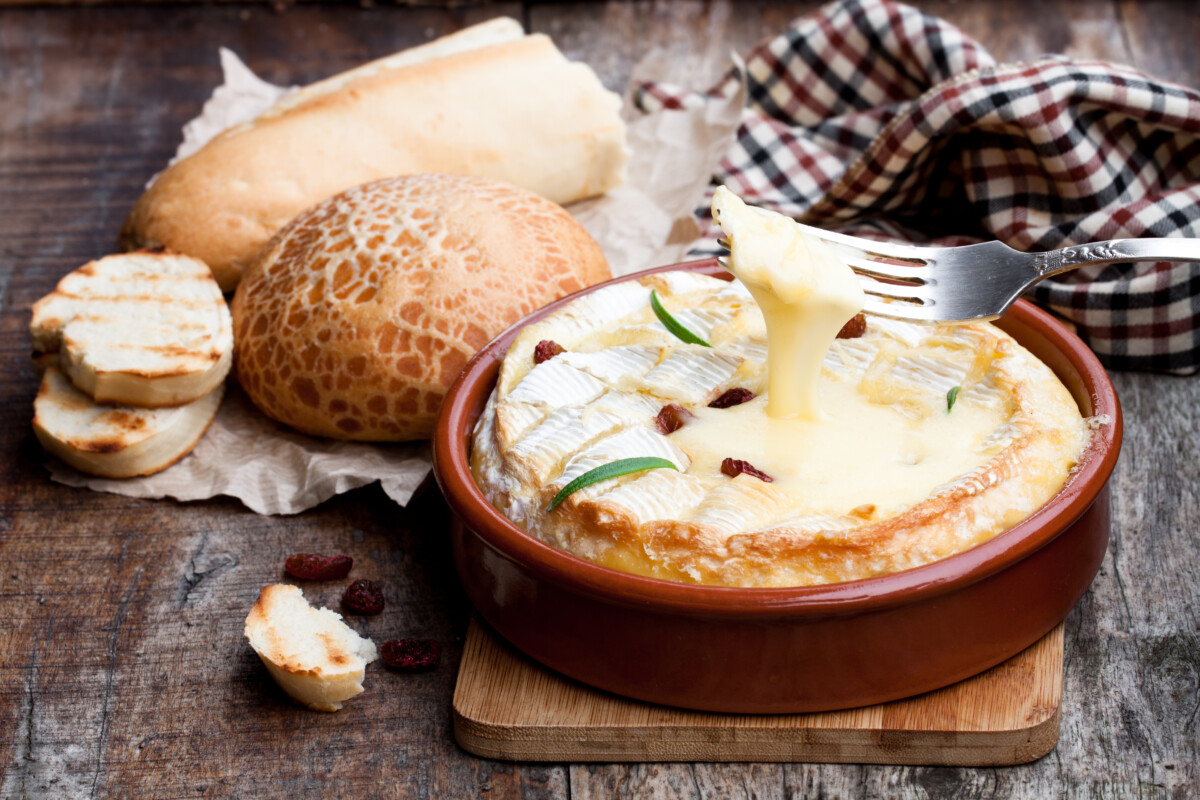 Delicious  hot baked camembert with sultanas on wooden table
