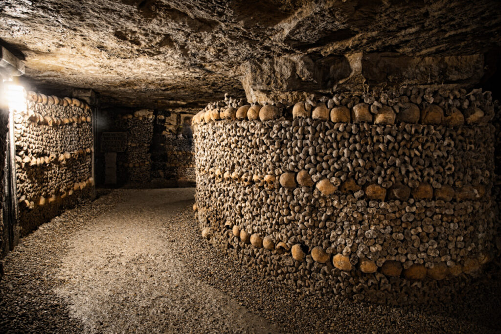 Pathway surrounded with skulls and bones in the Catacombs of Paris