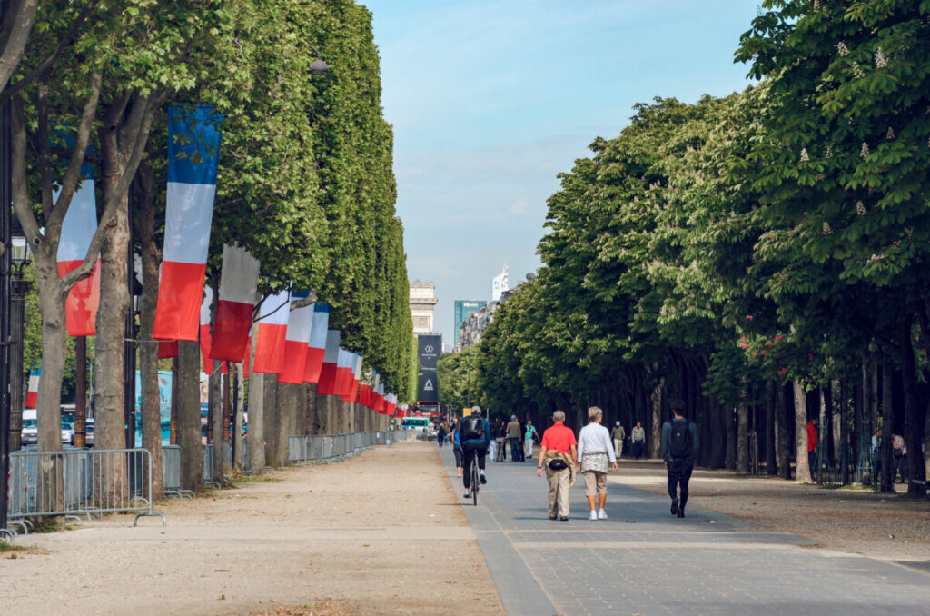 Tourists and locals strolling, walking, and biking at the Champs-Elysées in Paris, France